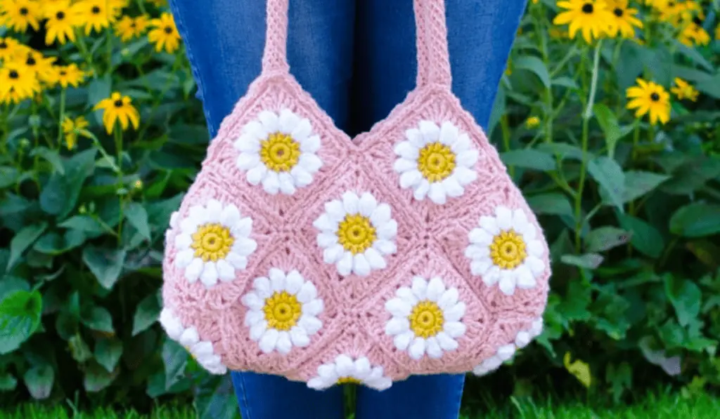 A pink crochet bag with daisy granny squares.