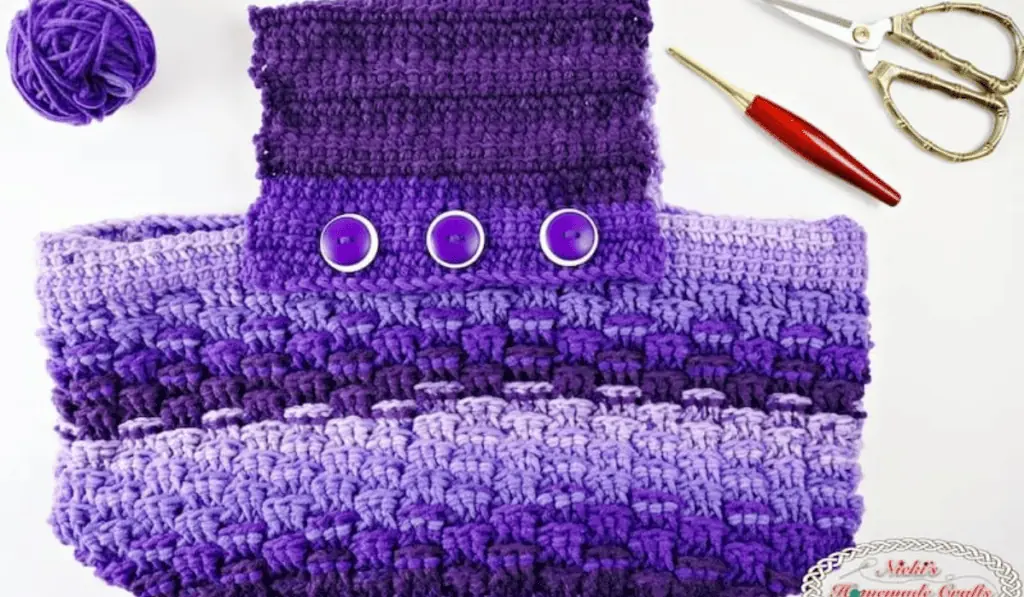 A crochet bag with a large handle to fit under your arm. This bag is made out of a variety of purple yarns.