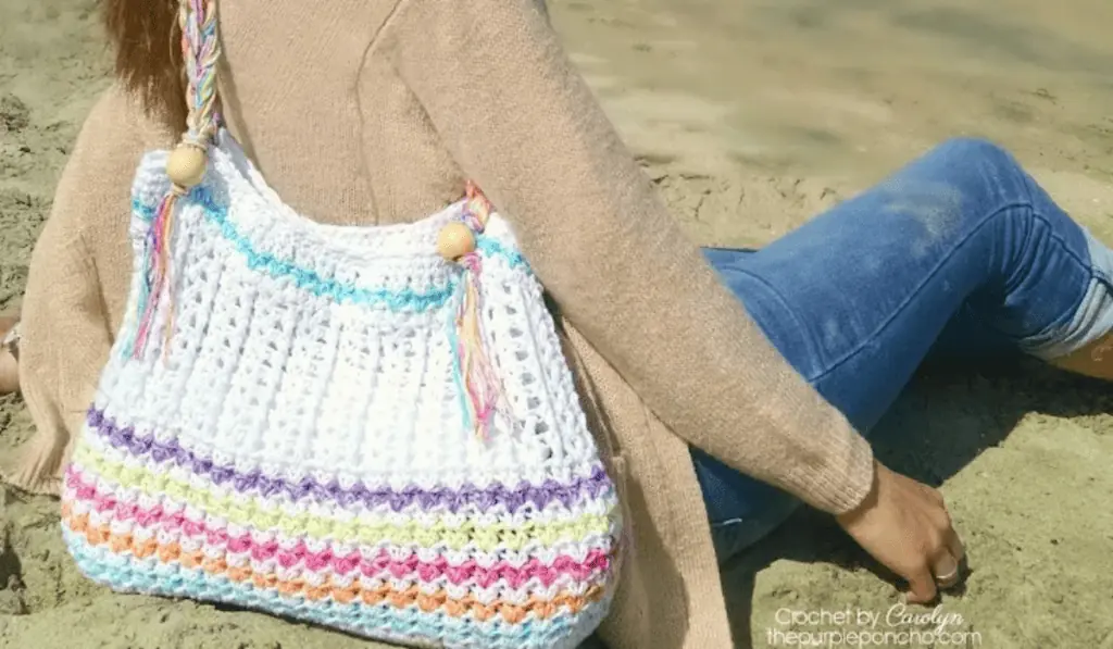 A mostly white crochet back with lines of purple, yellow, pink, orange, and blue yarn.