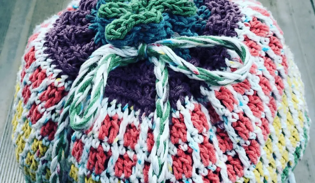 A crochet circular bag with a drawstring closure.