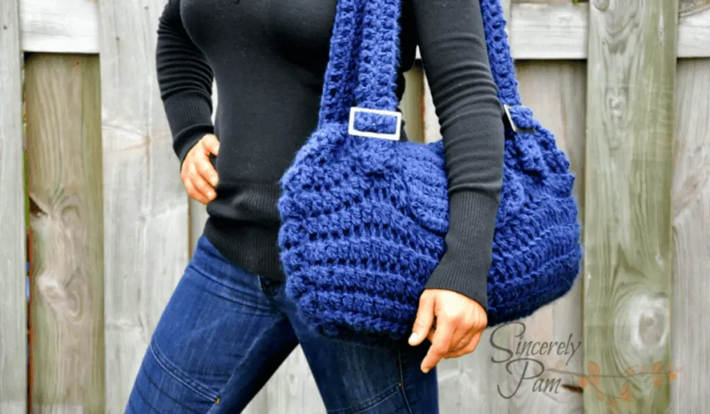 A blue crochet shoulder bag with long straps