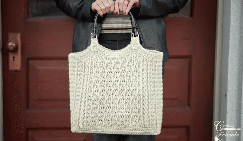 A white crochet tote bag with small handles