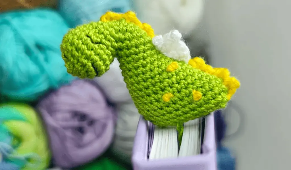 A green crochet dinosaur bookmark.