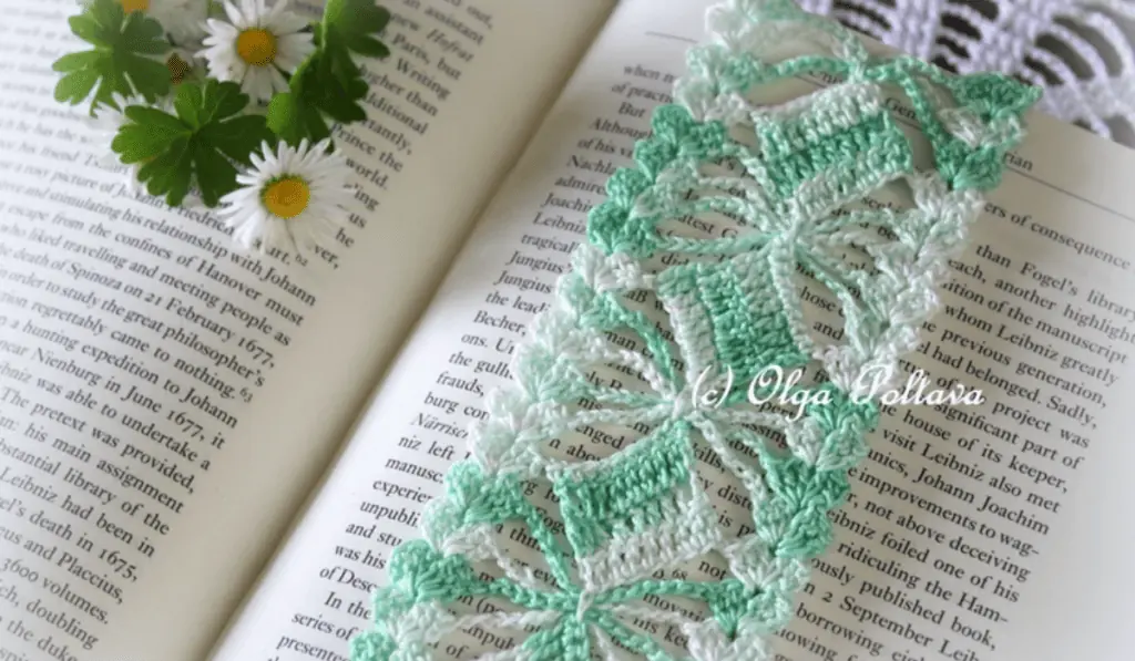 A green and white lacy crochet bookmark.