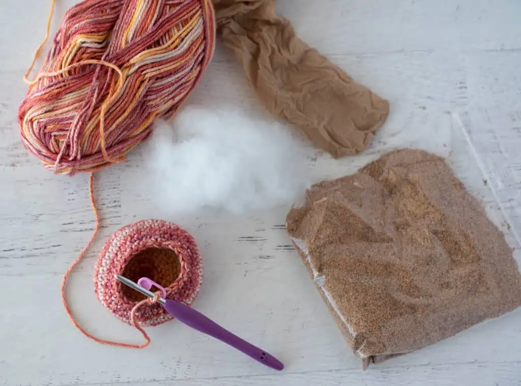 Orange variegated yarn, stuffing, crushed walnuts and panty hose