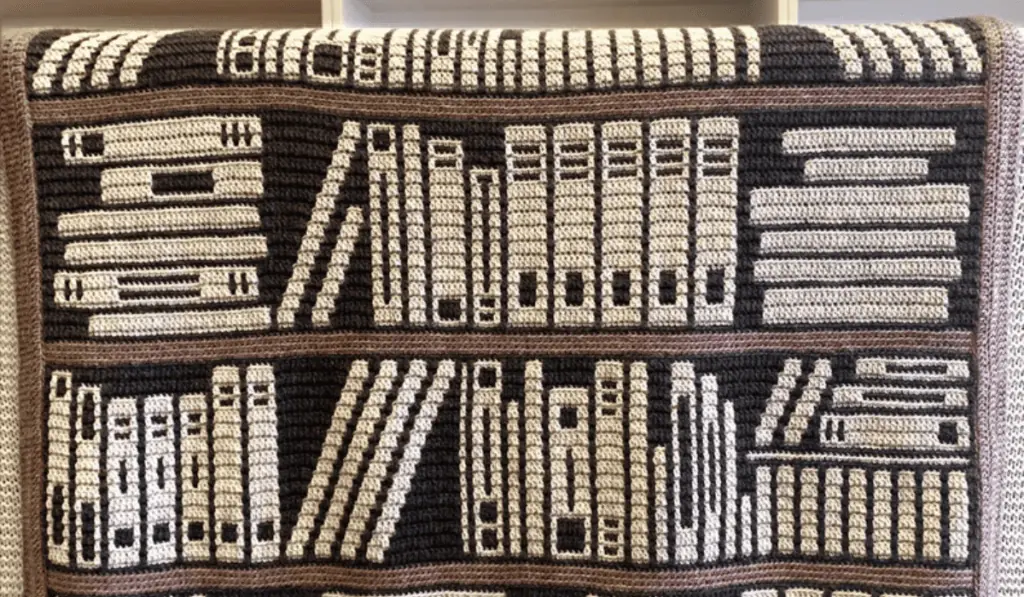 A mosaic crochet pattern that loooks like a bookshelf with different book spines on a afghan.