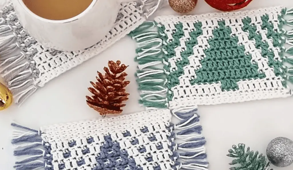 A photo of three mosaic crochet coasters that feature pine trees.