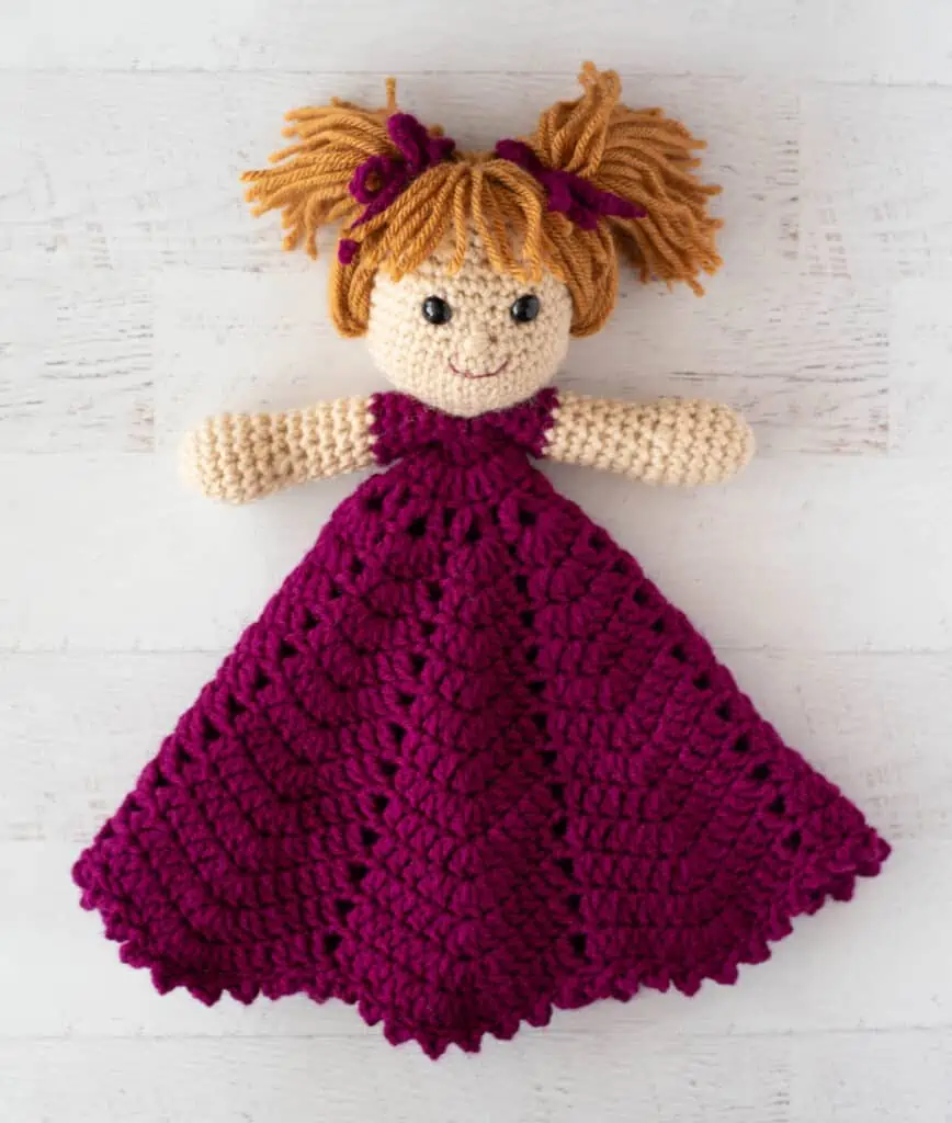 crochet princess lovey, folded, in dark pink berry dress and blonde hair