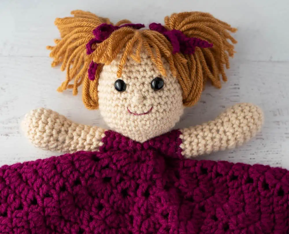 Up close view of facial features on crochet lovey doll