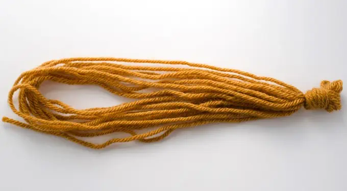 strands of gold yarn with a knot at one end