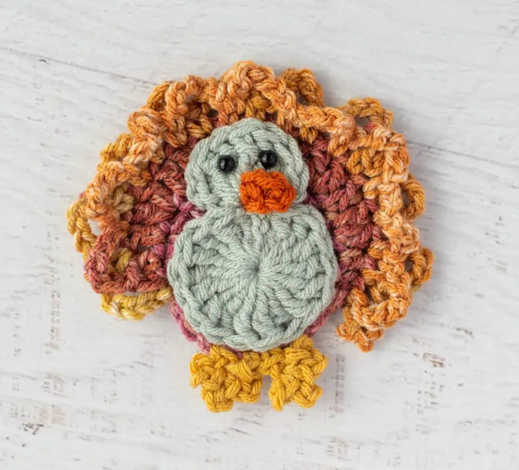 Crochet turkey with blue gray body and yellow feet