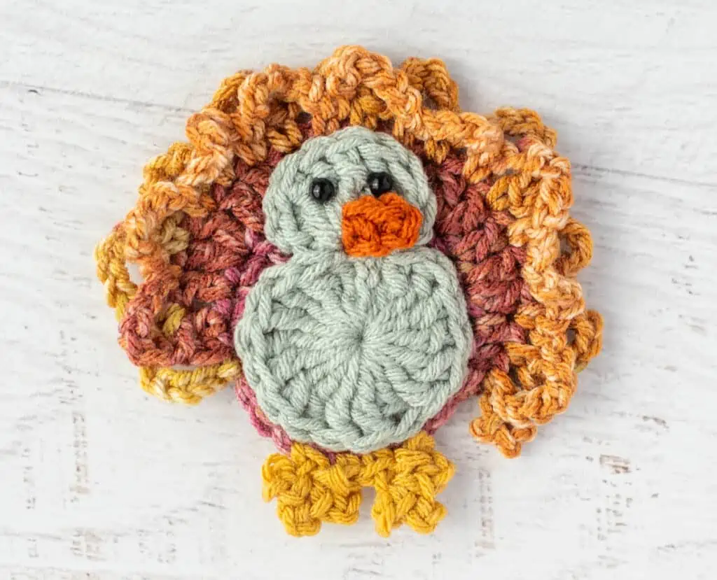 Crochet turkey with blue gray body and yellow feet