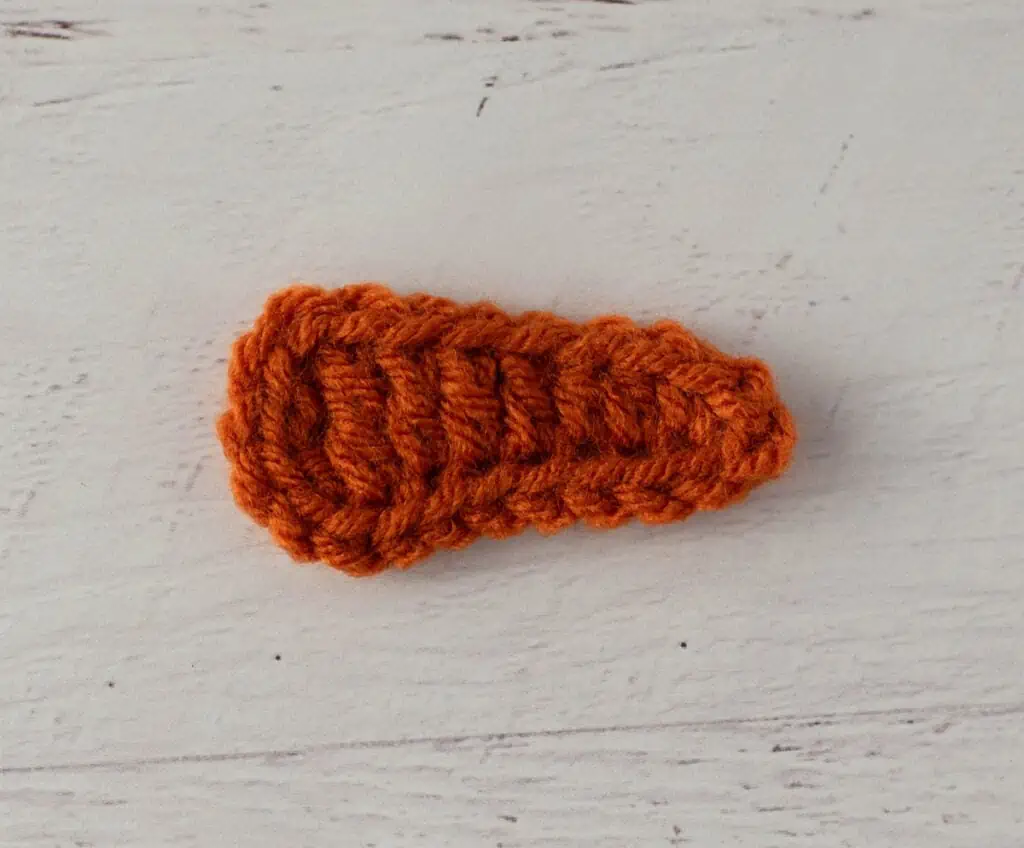 Crochet carrot nose out of orange yarn