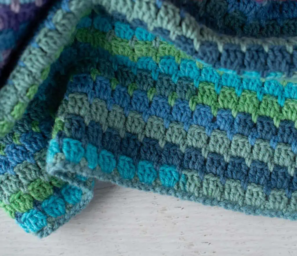 Up close view of blue and green crochet afghan