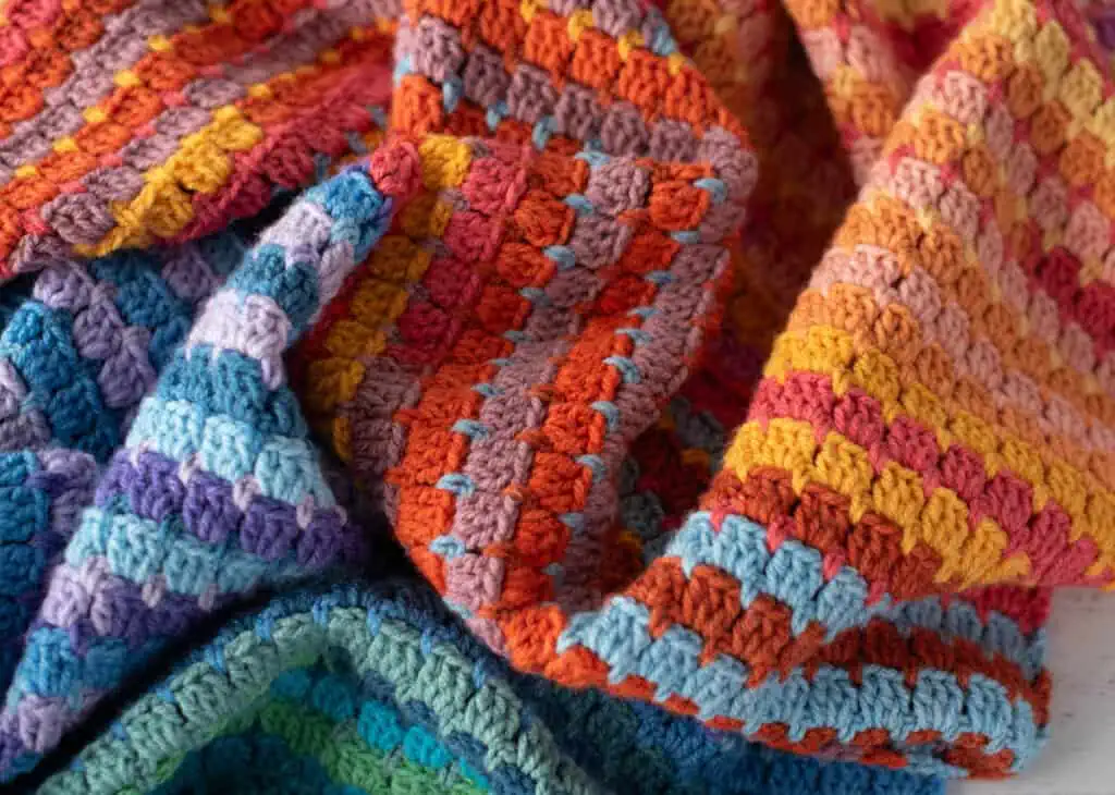 Multicolor yarn crochet afghan in orange, blue, purple assorted shades