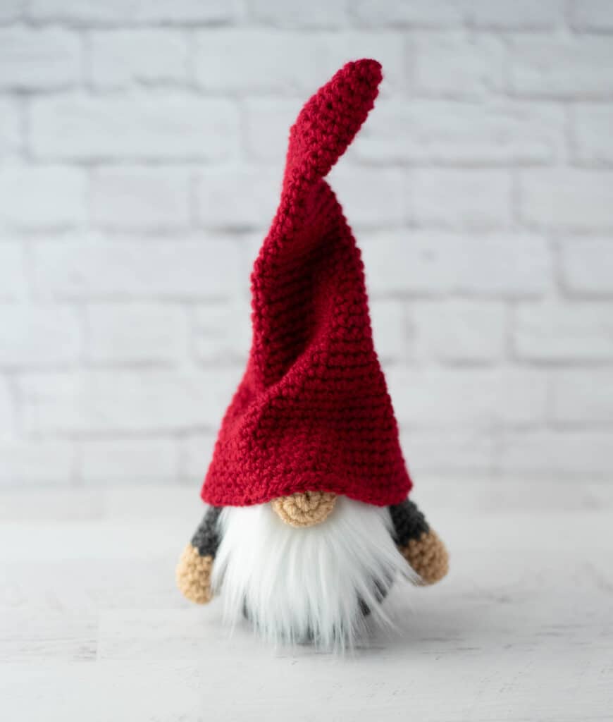 Gray crochet gnome with tall, red hat and furry white beard