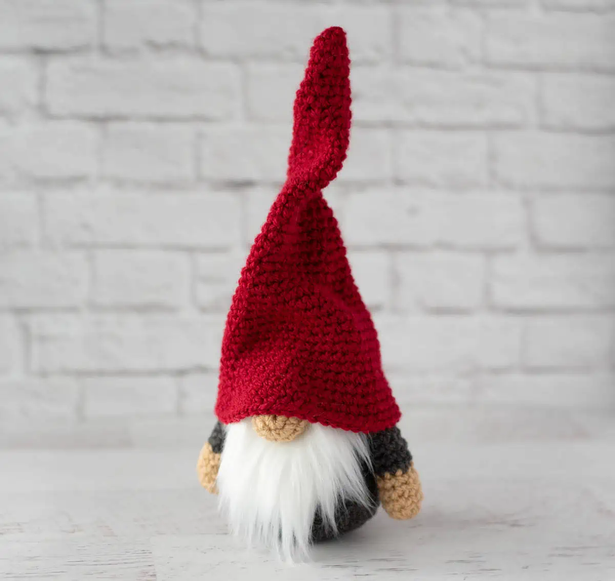 Gray crochet gnome with tall, red hat and furry white beard