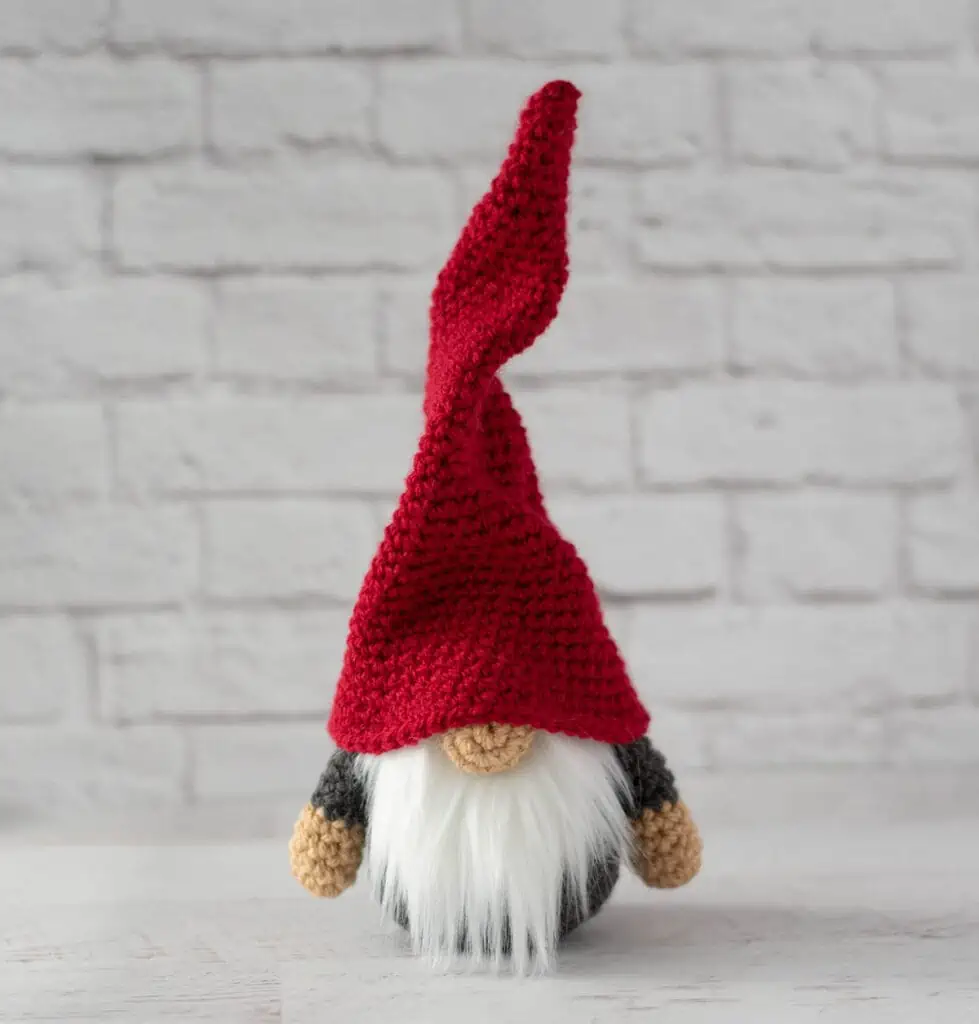 Gray crochet gnome with tall, red hat and furry white beard