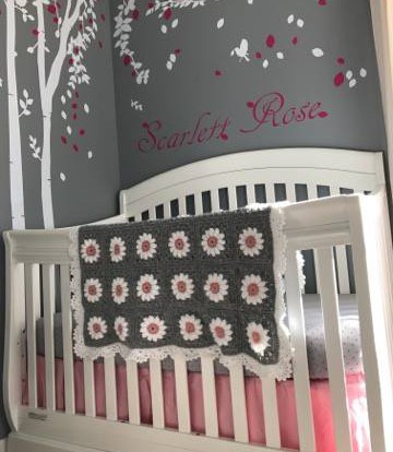 Crochet daisy baby afghan laying on crib.