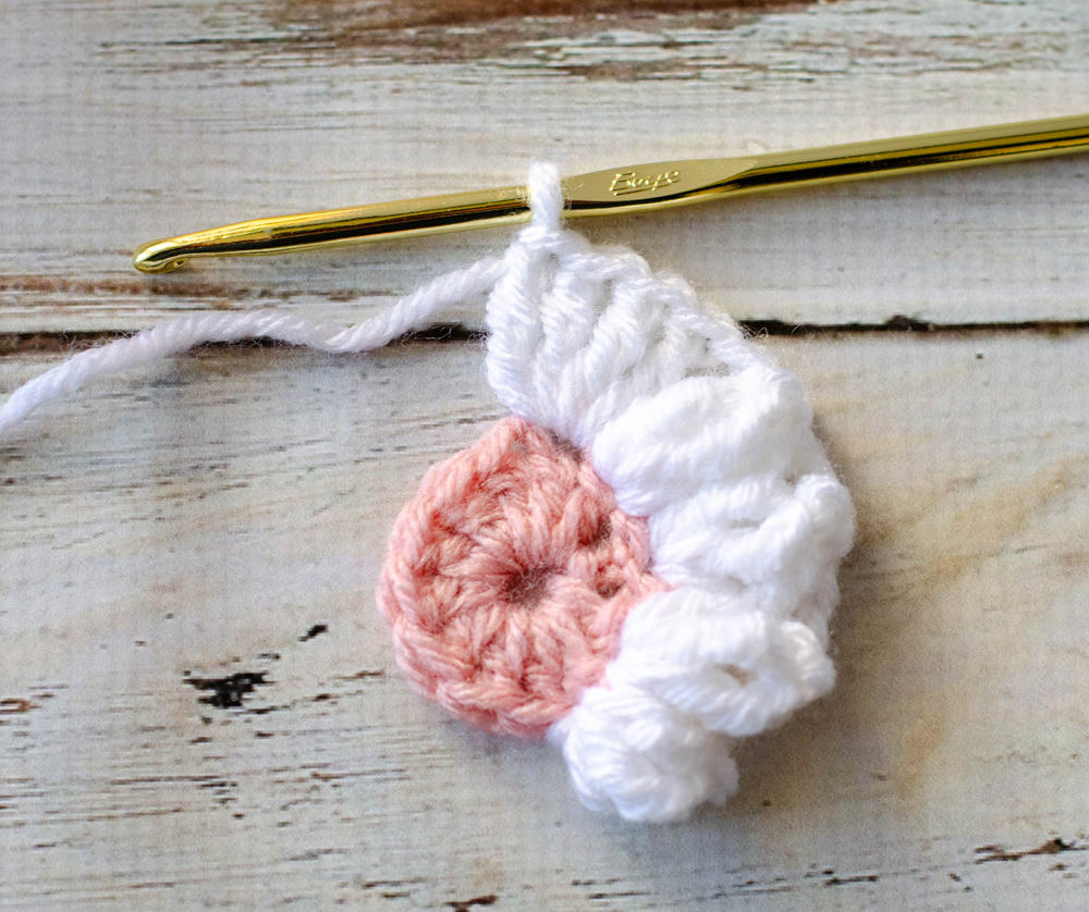 Start of crochet daisy afghan block with pink center and white petals