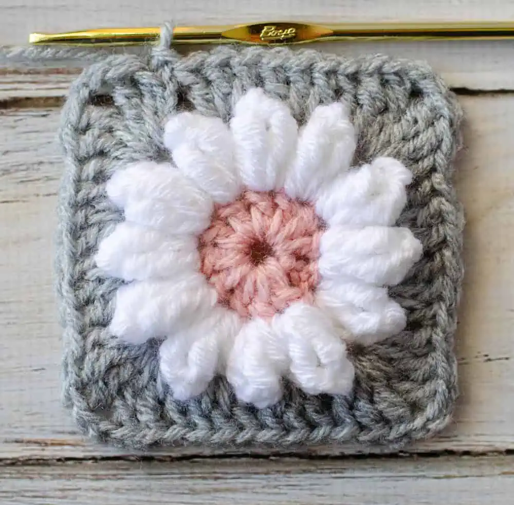 crocheting gray border around white and pink crochet daisy