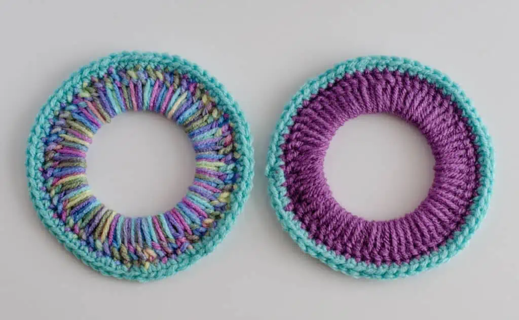 two crocheted rings. One is in blue and purple variegated yarn. The other is in purple with blue border.