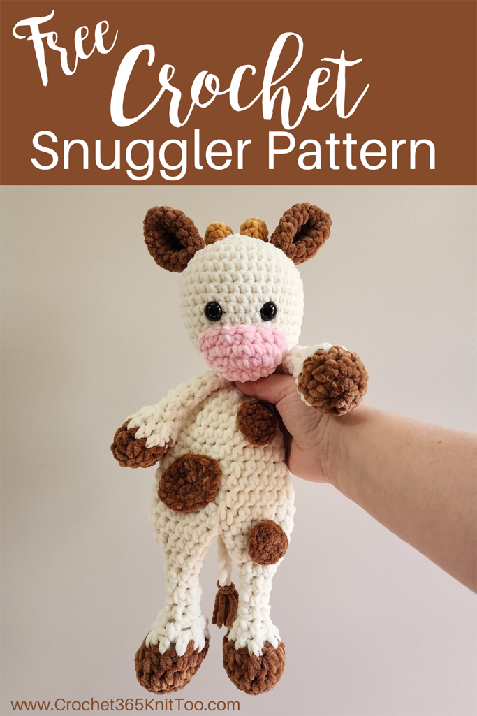 Image of crochet cow snuggler made in cream, brown and pink chenille yarn.