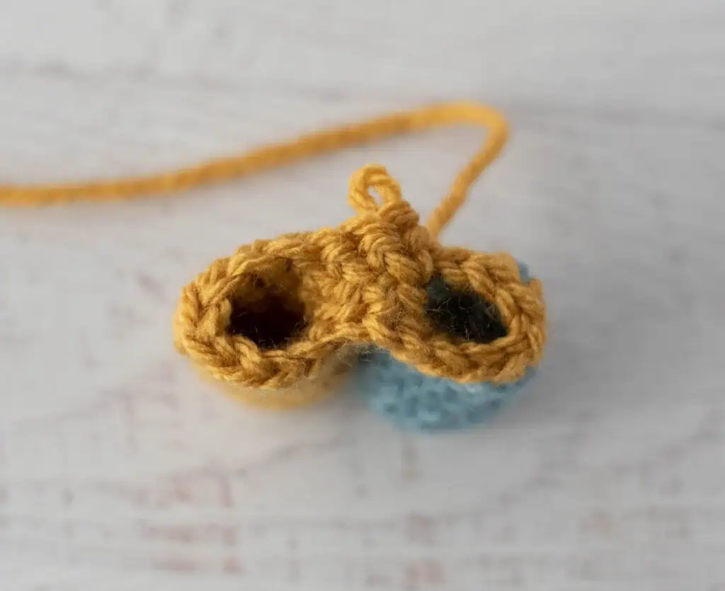 crochet limb connection process with yellow and blue yarn