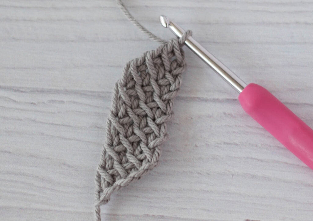 crochet strap in gray yarn with a pink crochet hook