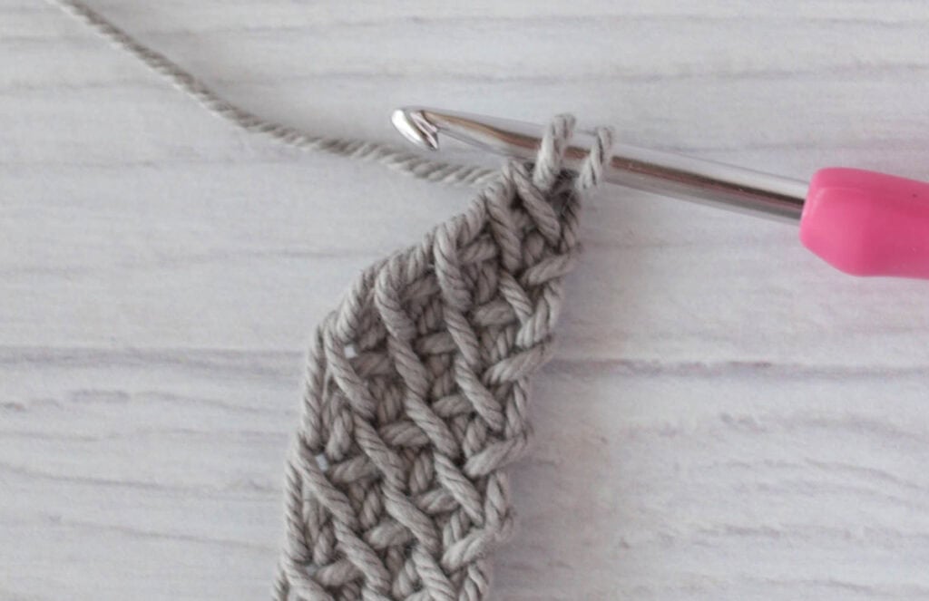 crochet strap in gray yarn with a pink crochet hook
