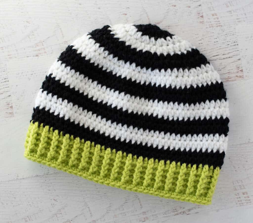 Black and white crocheted beanie with bright green brim
