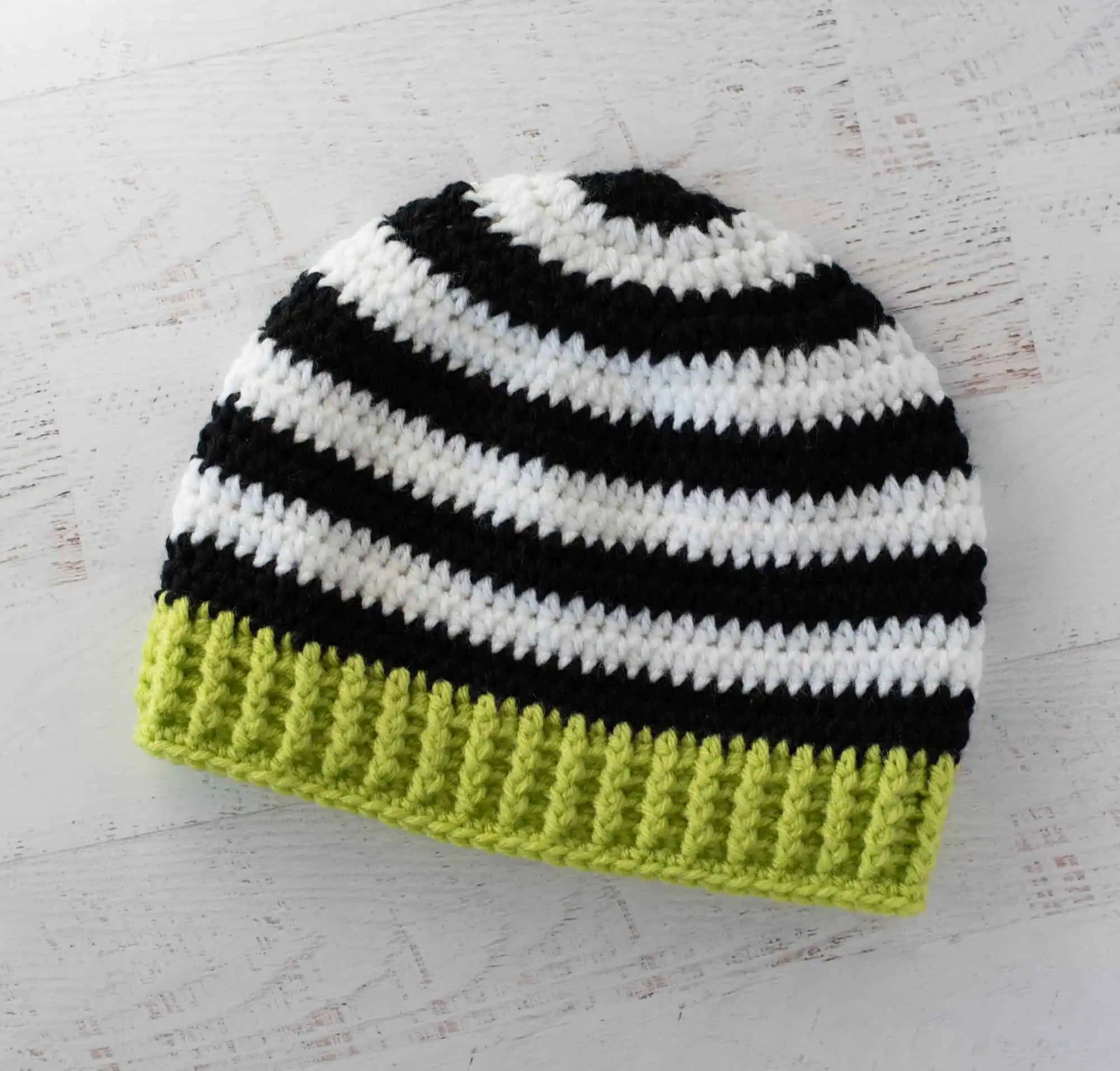 Black and white crocheted beanie with bright green