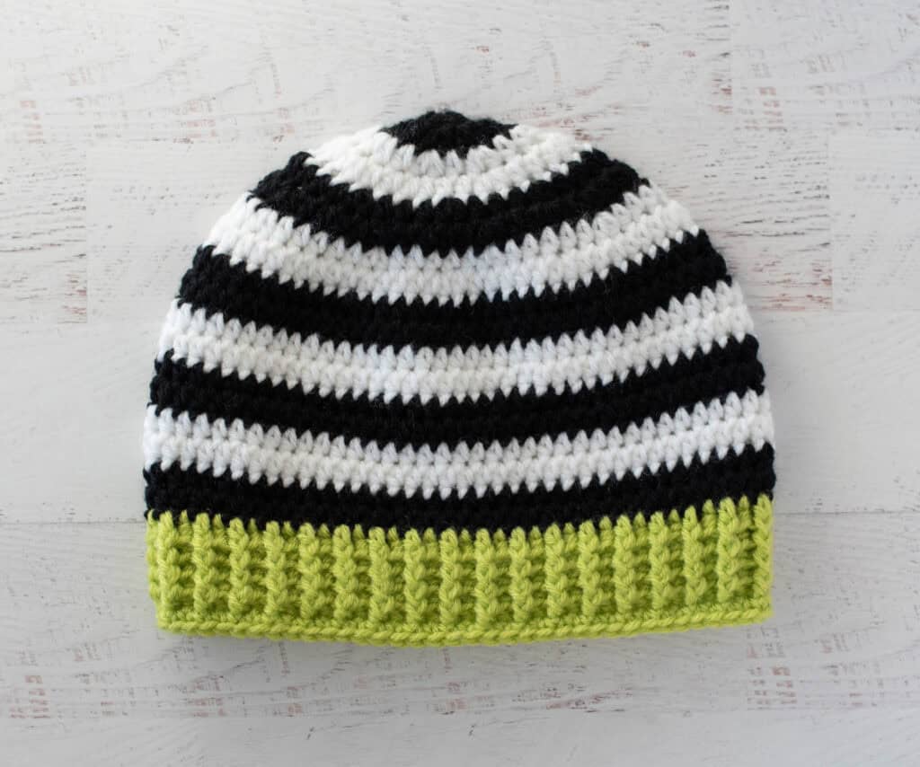 Black and white crocheted beanie with bright green brim