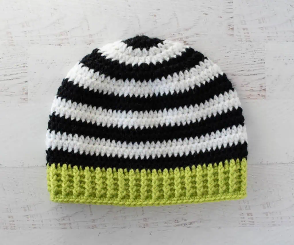 Black and white crocheted beanie with bright green brim