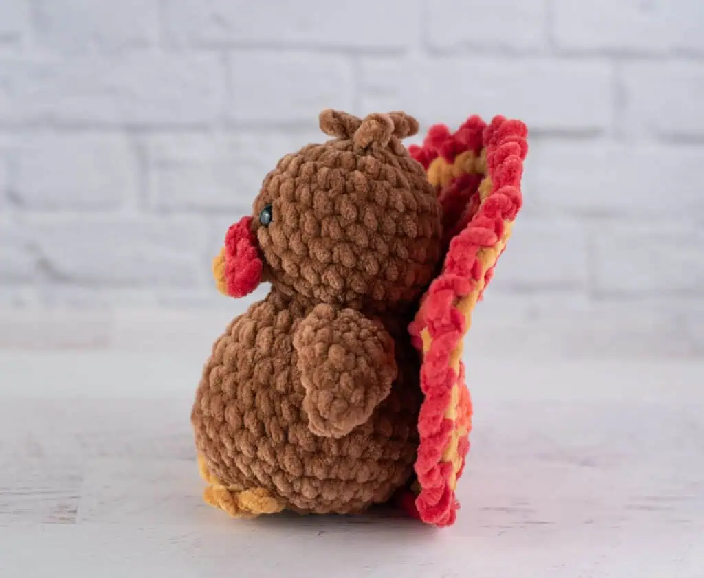 Side view of Crochet brown turkey with red, gold and orange accents