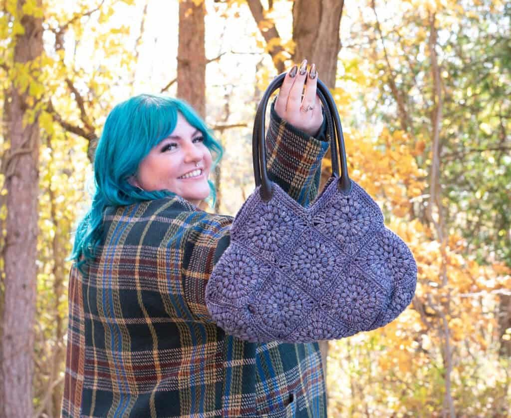 Girl with blue hair in fall street scene holding blue crochet bag