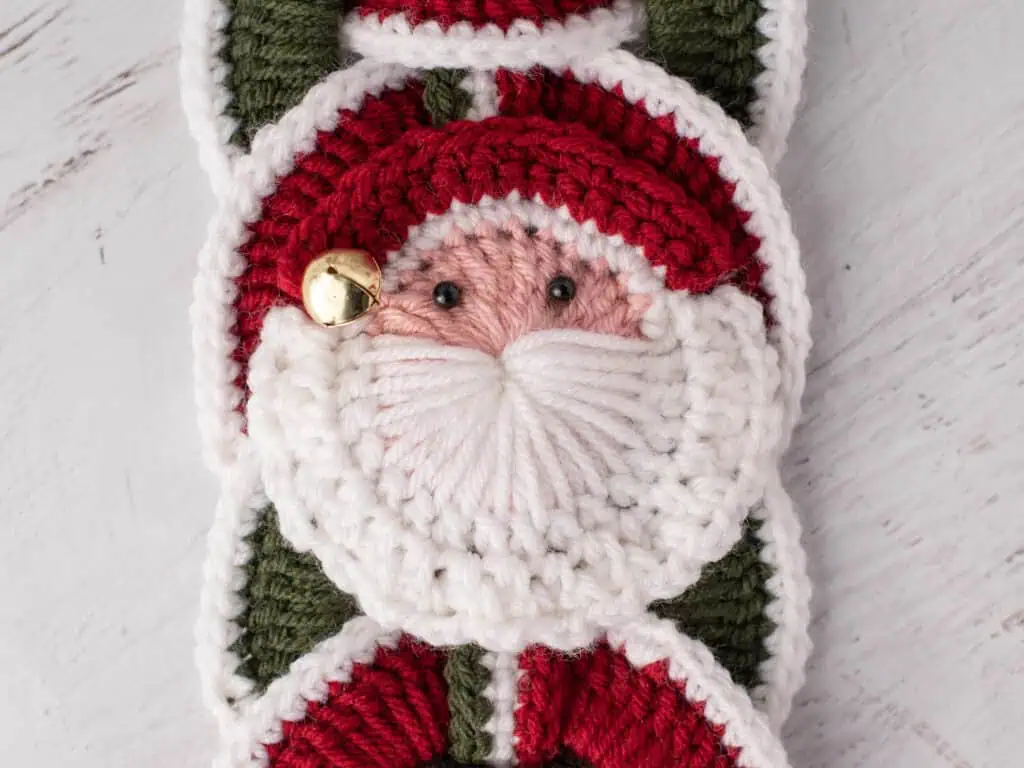 Crochet santa applique on red and green crochet wallhanging