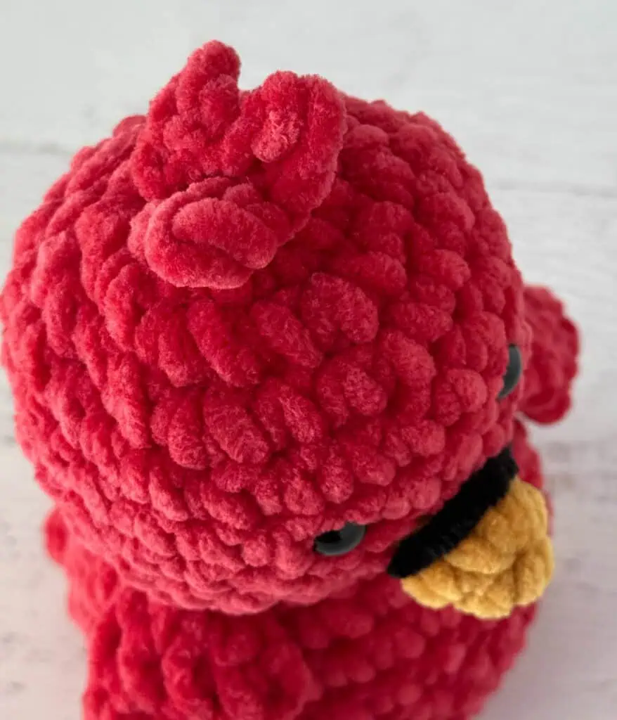 Top of crochet bird head in red yarn