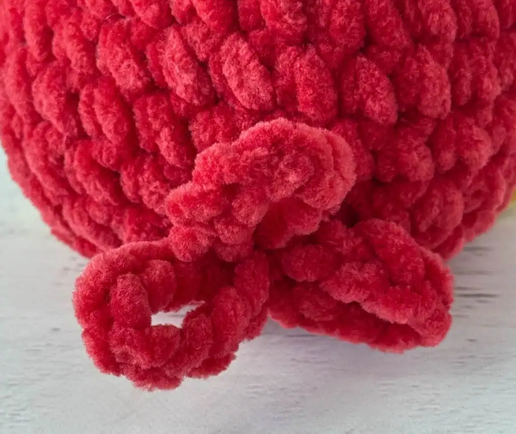 tail detail for crochet bird in red yarn