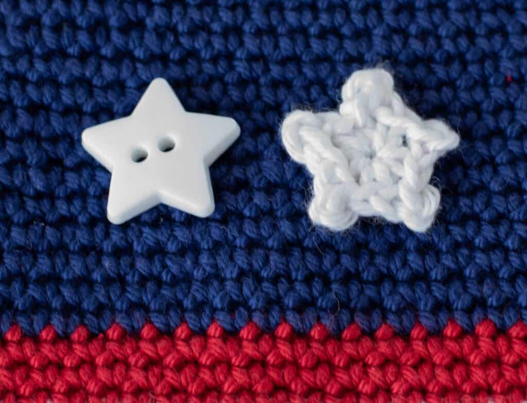 close up of crochet white star and white button on blue and red crochet background