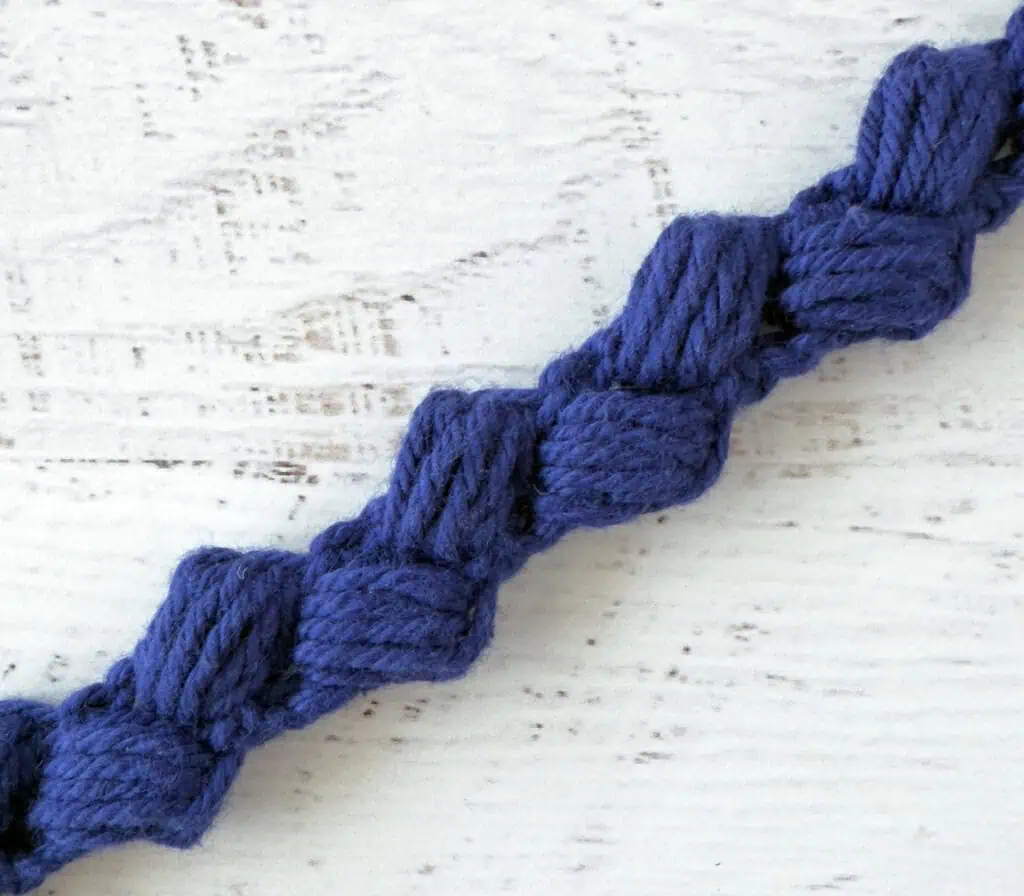 Close up of crochet bag strap in blue yarn