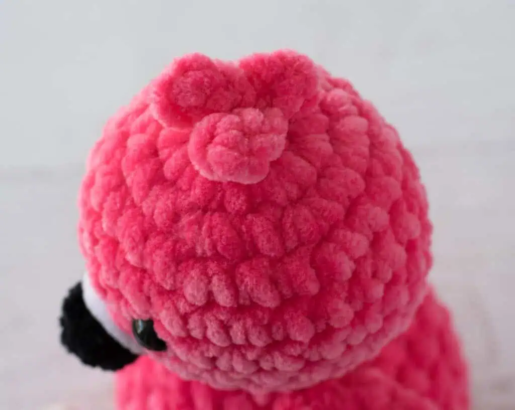 close up of top feathers of bright pink crochet flamingo