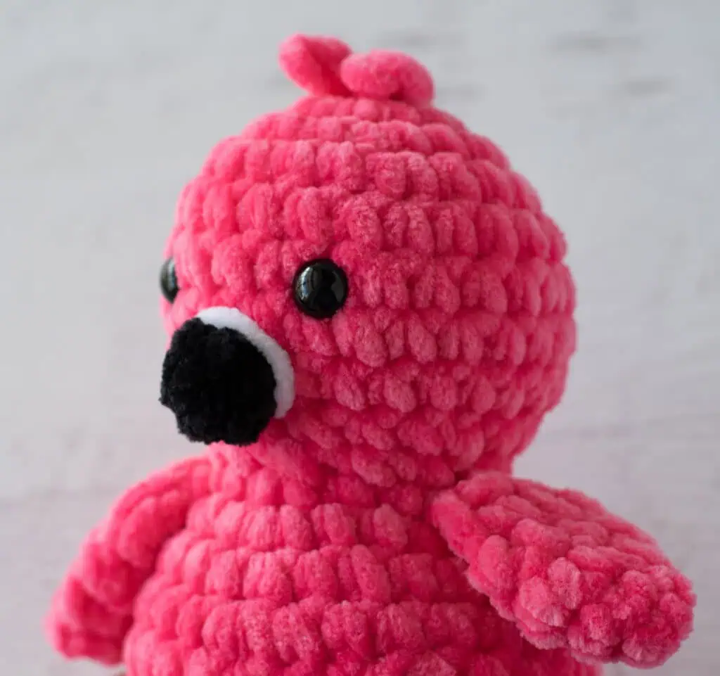 close up of bright pink crochet flamingo