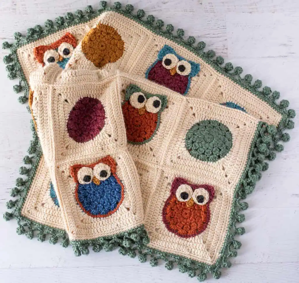 Colorful crochet owl blanket, handmade with vibrant yarns, perfect for cozy home decor and gift-giving.
