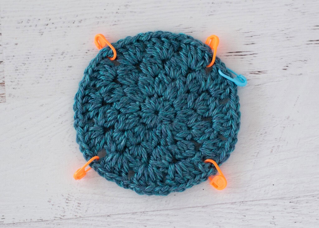 blue crochet motif with stitch markers
