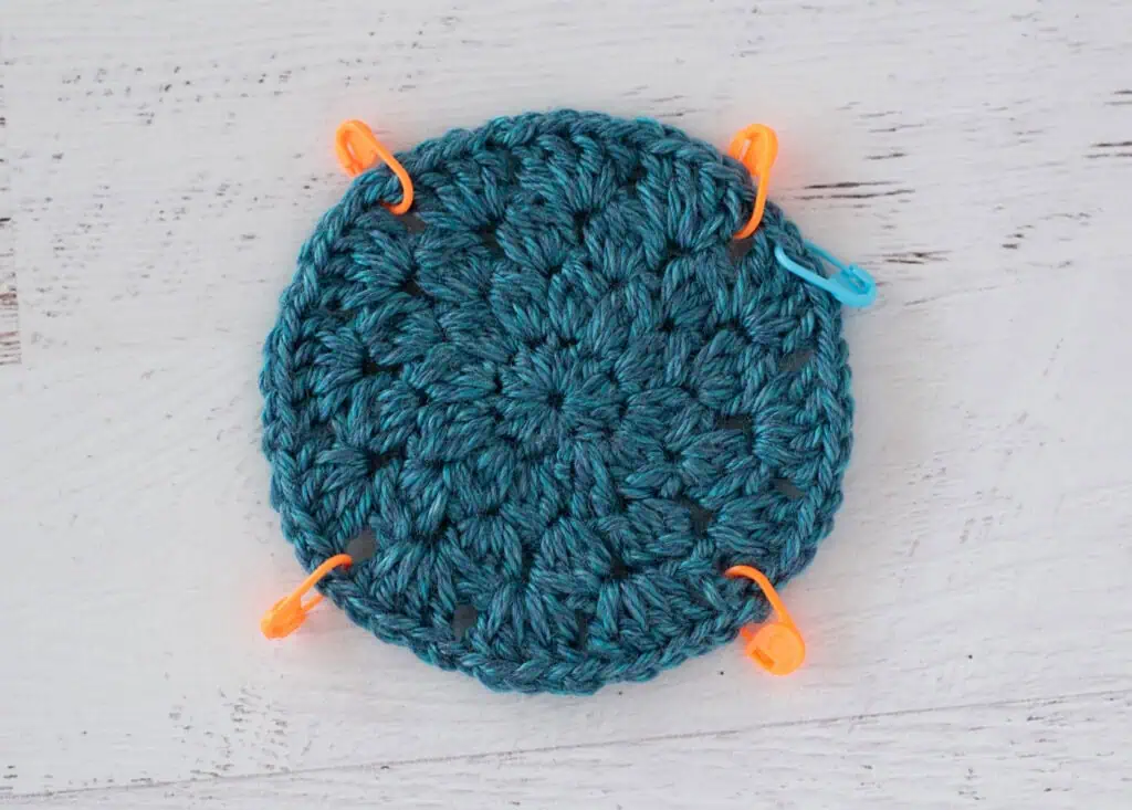 blue crochet motif with stitch markers