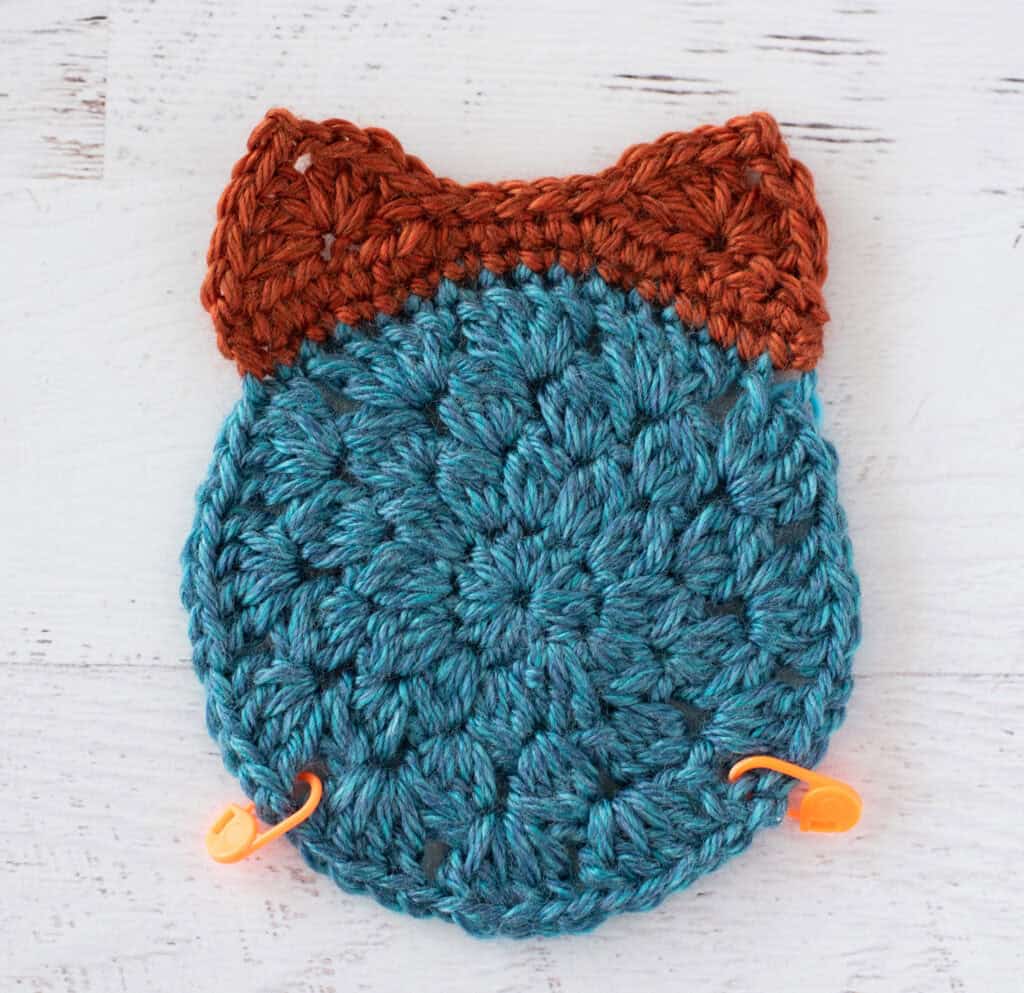 Crochet blue and orange afghan motif with orange stitch markers