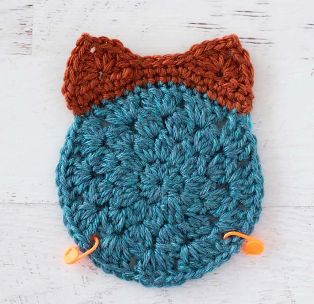 Crochet blue and orange afghan motif with orange stitch markers