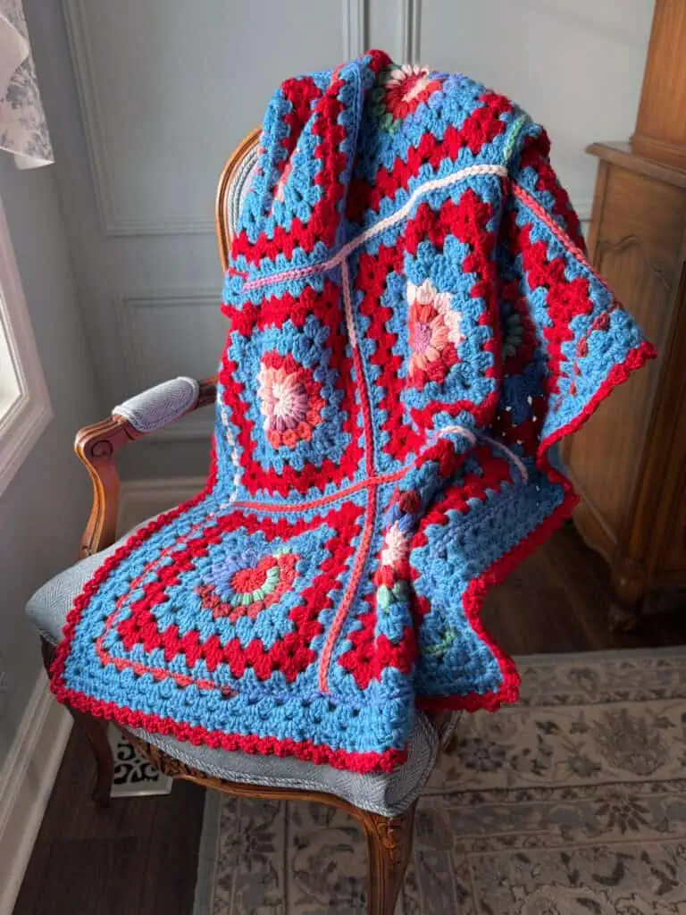Colorful crochet afghan on a chair by a window