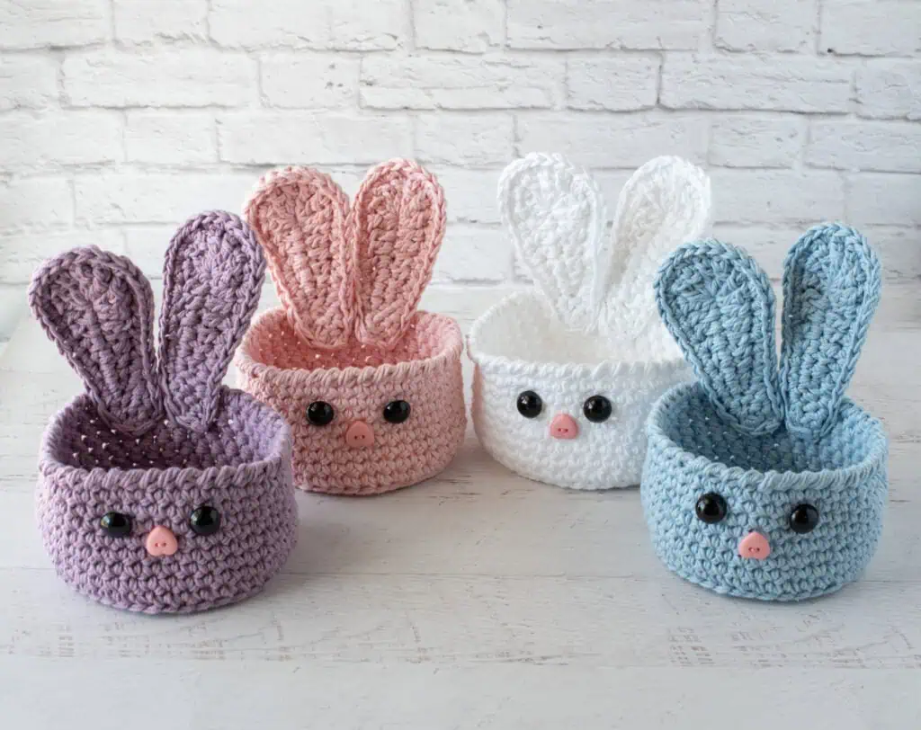 bunny baskets out of purple, pink, white and blue yarn